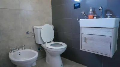 a bathroom with a toilet and a sink at Complejo Giraluna in Almafuerte