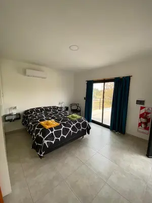 a bedroom with a bed and a large window at Complejo Giraluna in Almafuerte