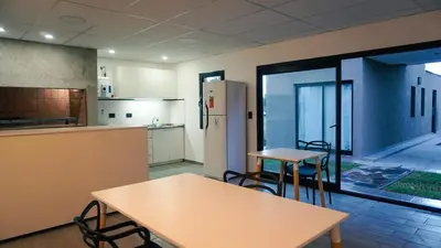 a kitchen with tables and chairs and a refrigerator at Complejo Giraluna in Almafuerte