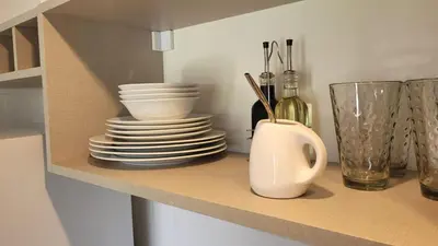 a shelf with plates and utensils in a kitchen at Mirada al Champaqui - Departamento de Montaña in Villa Yacanto