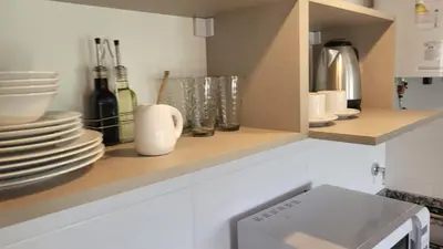 a kitchen with plates and dishes on a shelf at Mirada al Champaqui - Departamento de Montaña in Villa Yacanto