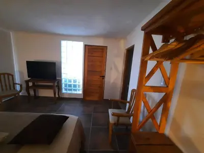 a bedroom with a bed and a tv and a ladder at Mirada al Champaqui - Departamento de Montaña in Villa Yacanto