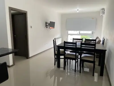 a dining room with a black table and chairs at Edificio Veneto IV - Departamento centrico frente al puente peatonal in Villa Carlos Paz