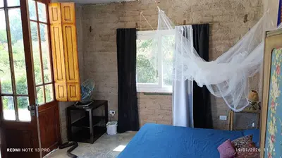 a bedroom with a blue bed and a window at Casa de adobe Cuesta blanca in Cordoba