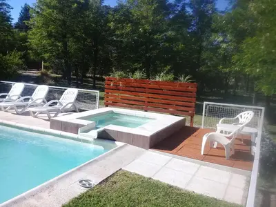a group of chairs sitting around a swimming pool at Alma Serrana Apart Cabañas - Solo Adultos in Nono