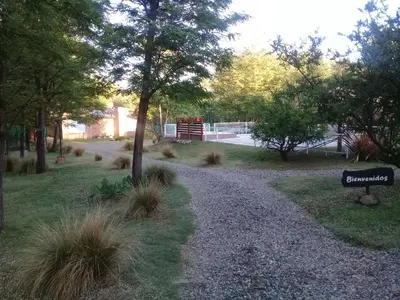 a gravel path with a sign in a park at Alma Serrana Apart Cabañas - Solo Adultos in Nono
