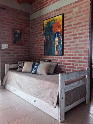a bed in a room with a brick wall at Alma Serrana Apart Cabañas - Solo Adultos in Nono
