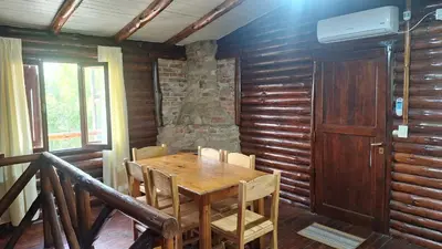 a wooden dining room with a wooden table and chairs at Balcón de Los Aromos in La Bolsa