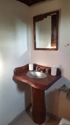 a bathroom with a wooden sink and a mirror at Balcón de Los Aromos in La Bolsa