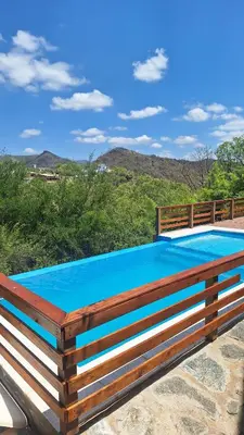 a swimming pool with a wooden fence around it at Balcón de Los Aromos in La Bolsa