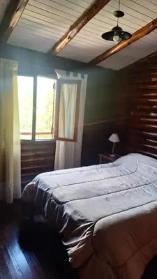 a bedroom with a large bed and two windows at Balcón de Los Aromos in La Bolsa
