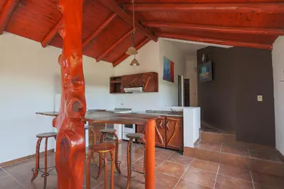 a kitchen with a wooden table and stools at Cabañas La Ernestina in Villa Carlos Paz