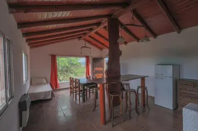 a kitchen and dining room with a table and chairs at Cabañas La Ernestina in Villa Carlos Paz