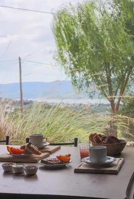 a wooden table with food and coffee cups on it at Cabañas La Ernestina in Villa Carlos Paz