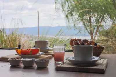 a table with a plate of fruit and a glass of juice at Cabañas La Ernestina in Villa Carlos Paz