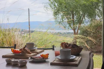 a table with a breakfast of coffee and fruit on it at Cabañas La Ernestina in Villa Carlos Paz