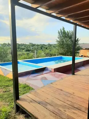 a swimming pool with a wooden deck in front of a house at La Posada De Vito in Cordoba