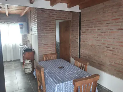 a dining room with a table and a brick wall at La Posada De Vito in Cordoba