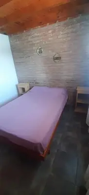 a large bed in a room with a brick wall at La Posada De Vito in Cordoba