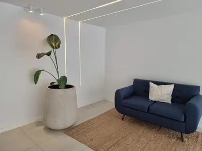 a blue couch and a potted plant in a room at Dpto en Planta Baja Cba Cap con seguridad in Cordoba