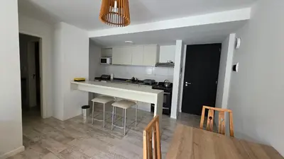 a kitchen with a counter and stools in a room at Dpto en Planta Baja Cba Cap con seguridad in Cordoba