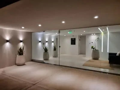 a lobby with a glass wall with plants in it at Dpto en Planta Baja Cba Cap con seguridad in Cordoba