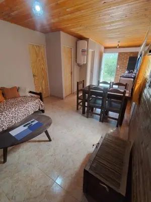 a living room with a bed and a dining room at Cabaña Claro de Luna in Merlo