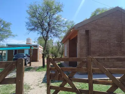 a wooden fence in front of a brick building at Cabaña Claro de Luna in Merlo