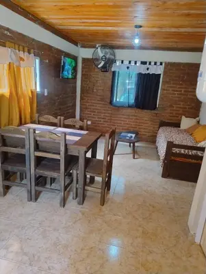 a dining room with a table and chairs and a couch at Cabaña Claro de Luna in Merlo