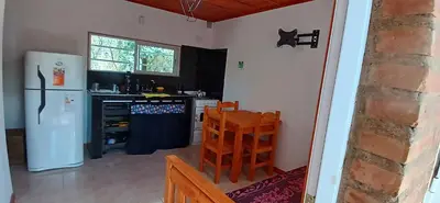 a kitchen with a refrigerator and a table and chairs at Cabaña Claro de Luna in Merlo