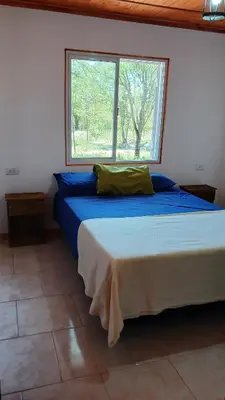 a bedroom with a large bed with a window at Cabaña Claro de Luna in Merlo