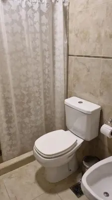 a bathroom with a toilet and a shower and a sink at Departamento frente a lago Carlos Paz - Villa Siquiman - Complejo Veneto Village in Villa Parque Siquiman