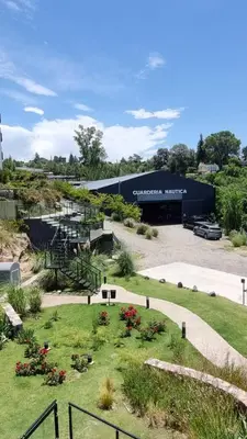 a building with a garden in front of it at Departamento frente a lago Carlos Paz - Villa Siquiman - Complejo Veneto Village in Villa Parque Siquiman