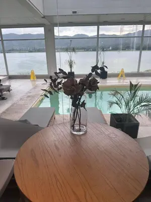 a vase of flowers sitting on a wooden table at Departamento frente a lago Carlos Paz - Villa Siquiman - Complejo Veneto Village in Villa Parque Siquiman