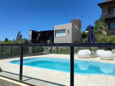 a view of a swimming pool from a house with a fence at LA CASITA in Villa Carlos Paz