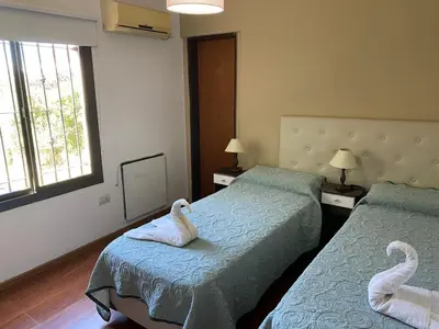 two beds in a hotel room with swans on them at LA CASITA in Villa Carlos Paz