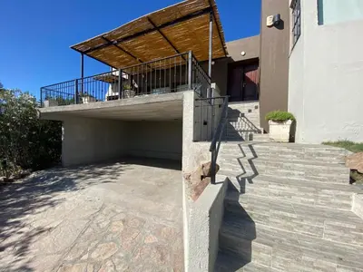a house with a balcony with a wooden roof at LA CASITA in Villa Carlos Paz