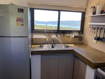 a kitchen with a sink and a refrigerator at LA CASITA in Villa Carlos Paz