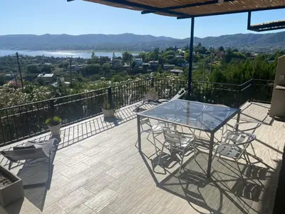 a patio with a table and chairs on a balcony at LA CASITA in Villa Carlos Paz