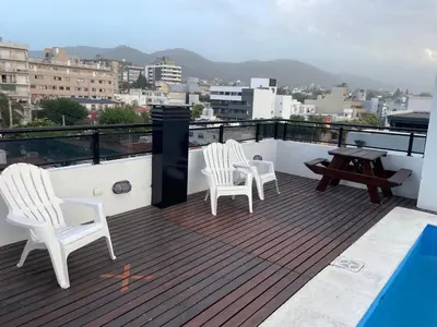 two white chairs and a table on a roof at VENECIA céntrico con balcón in Villa Carlos Paz