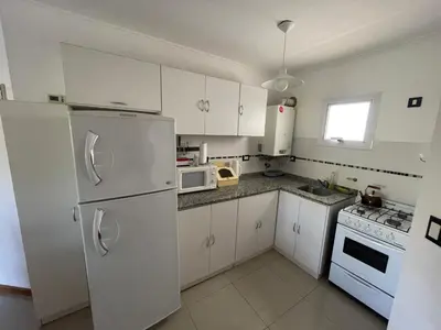 a kitchen with white cabinets and a white refrigerator at VENECIA céntrico con balcón in Villa Carlos Paz