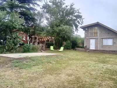 a yard with a house with a lawn sidx sidx sidx sidx at Chalet y Cabaña de montaña Esmeralda in Villa del Dique