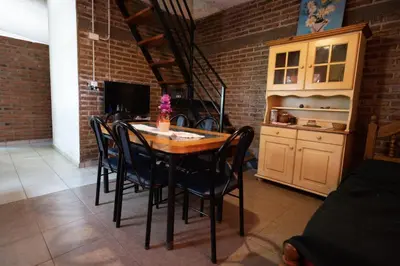 a dining room with a table and chairs and a staircase at Chalet y Cabaña de montaña Esmeralda in Villa del Dique