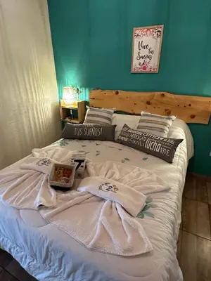 a bed with white sheets and towels on it at Complejo de Cabañas Los 2 Soles 9 in Los Reartes