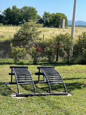 two benches sitting in the grass in a field at Complejo de Cabañas Los 2 Soles 9 in Los Reartes