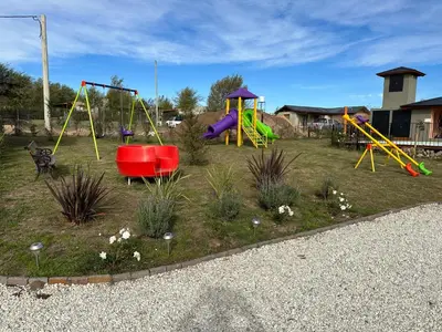 a park with a playground with slides and swings at Complejo de Cabañas Los 2 Soles 9 in Los Reartes