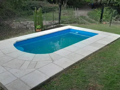 a swimming pool in a yard with a concrete floor at El Rinconcito de la Selva in La Calera