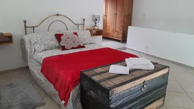 a bedroom with a large bed with a red blanket at El Rinconcito de la Selva in La Calera