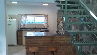 a kitchen with a green staircase and a refrigerator at El Rinconcito de la Selva in La Calera