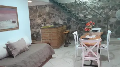 a room with a couch and a table with chairs at El Rinconcito de la Selva in La Calera